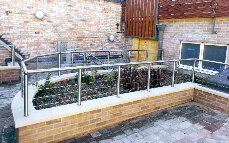 Tension wire railing on planter wall